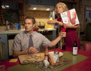 Burt and Virginia prepare for wealthy guests, pouring box wine into empty bottles in an attempt to appear well-off